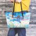 Dragonfly is flying over the grass leather tote bag