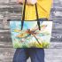 Dragonfly is flying over the grass leather tote bag