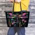 Dragonfly is flying surrounded by flowers leather tote bag