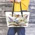 Dragonfly sitting on an open book surrounded flowers leather tote bag