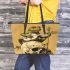 Green frog playing the banjo on top of human skull leaather tote bag
