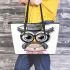 Grey owl with big eyes wearing glasses and graduation hat holding leather tote bag