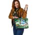 Colorful frogs hanging from tree branches in the jungle leaather tote bag