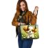 Cute cartoon puppy sitting on the grass leather tote bag