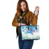Dragonfly is flying over the grass leather tote bag