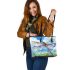 Dragonfly is flying over the grass leather tote bag