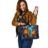 Two colorful owls sitting on the edge of an ornate mirror leather tote bag