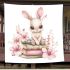 Rabbit sitting on top of books surrounded by flowers blanket