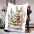 Baby rabbit sitting on top of books surrounded by flowers blanket