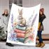 Rabbit sitting on top of books surrounded by flowers blanket