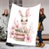 Rabbit sitting on top of books surrounded by flowers blanket