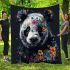 Panda with black and white fur and colorful floral blanket
