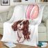 Brown and white king charles spaniel puppy with pink balloons blanket