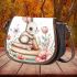 Baby rabbit sitting on top of books surrounded by flowers saddle bag