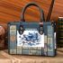 Blue butterfly with white flowers around small handbag