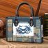Blue butterfly with white flowers around small handbag