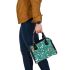 Butterflies and flowers scattered across shoulder handbag