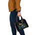 Colorful glowing butterfly surrounded by flowers and leaves shoulder handbag