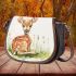 Cute baby deer sitting in the grass saddle bag