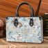 Cute bunnies and flowers on light blue small handbag