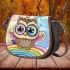 Cute cartoon owl with big eyes wearing a colorful saddle bag
