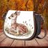 Cute little fawn sitting in the grass saddle bag