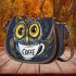 Cute owl with big yellow eyes holding a coffee cup saddle bag
