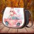 Cute pink owl sitting on top of a pastel car saddle bag