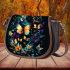 Glowing butterflies dance among vibrant flowers saddle bag