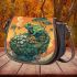 Green frog sitting on top of an island with trees and flowers saddle bag