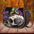 Green frog sitting on top of an skull with purple thistles growing saddle bag