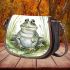 Happy frog sitting in the grass near a pond saddle bag