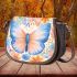 Orange butterfly surrounded by colorful spring flowers saddle bag