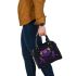 Purple frog with bright green eyes and on a solid shoulder handbag