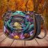 Vibrant teal frog with large eyes sits on top of colorful flowers saddle bag