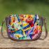 Abstract painting of musical notes and instruments saddle bag