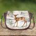 Adorable fawn standing in the snow saddle bag