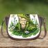 Cute frog sitting on the grass with flowers saddle bag