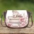 Rabbit sitting on top of books surrounded by flowers saddle bag