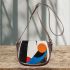 Abstract shapes contrasting colors of black and gold saddle bag