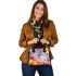 Colored butterfly surrounded by vibrant flowers shoulder handbag