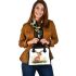 Cute baby deer sitting in the grass shoulder handbag