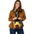 Cute bee sits on the petal of a sunflower shoulder handbag