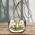 Cute cartoon frog sitting on the ground with pink flowers saddle bag