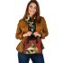 Green frog playing the banjo on top of human skull shoulder handbag