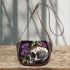 Green frog sitting on top of an skull with purple thistles growing saddle bag