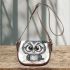 Grey owl with big eyes wearing glasses and graduation hat holding saddle bag