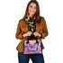 Orange butterfly surrounded by colorful spring flowers shoulder handbag