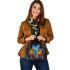 Two colorful owls sitting on the edge of an ornate mirror shoulder handbag