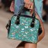 Butterflies and flowers scattered across shoulder handbag